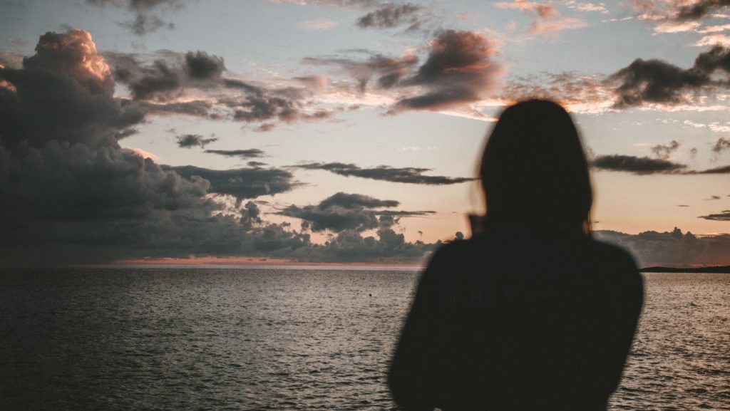 Woman standing alone on the beach