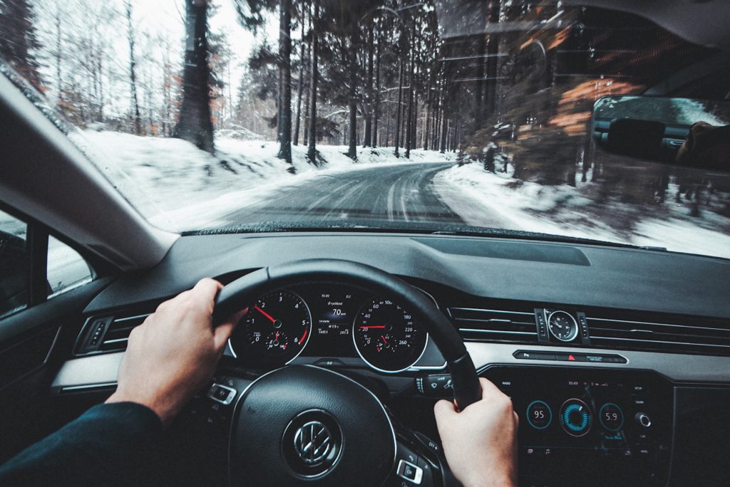 A man driving a car and going back to check things