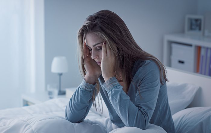 Woman rubbing her temples in fatigue.